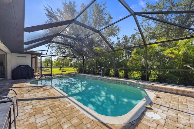 view of swimming pool featuring a grill, a lanai, and a patio area