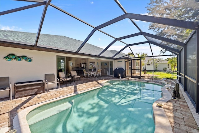 view of pool with a grill, a lanai, and a patio area