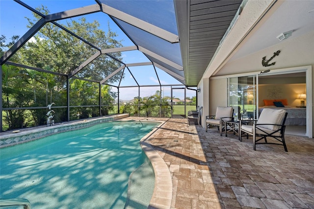 view of swimming pool featuring glass enclosure and a patio area