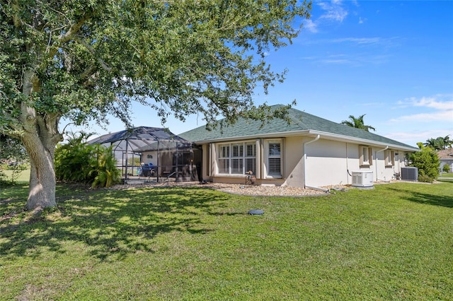 back of house featuring a lanai, a yard, and central AC unit