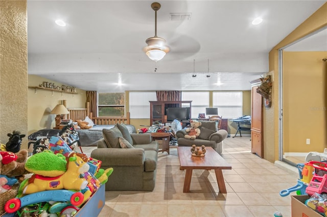 living room featuring a wealth of natural light, light tile patterned floors, and ceiling fan