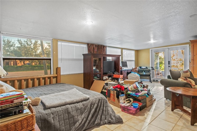 tiled bedroom with french doors, a textured ceiling, and access to outside