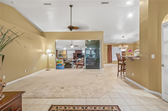 unfurnished living room featuring lofted ceiling, ceiling fan with notable chandelier, and light tile patterned floors