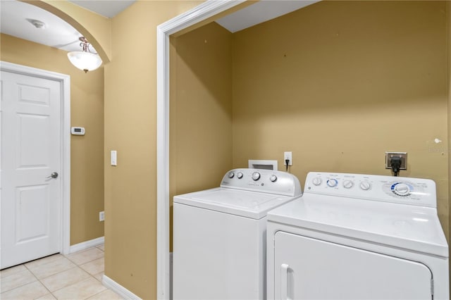 laundry area with washing machine and dryer and light tile patterned floors