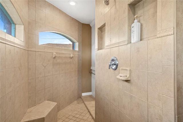 bathroom with a tile shower and tile patterned floors