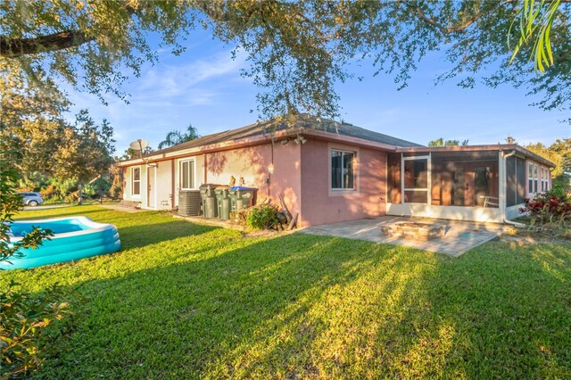 back of property with a patio area, a yard, and a sunroom