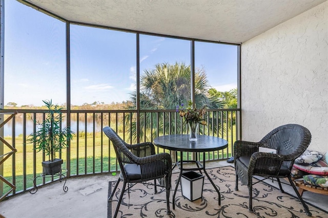 sunroom featuring a water view