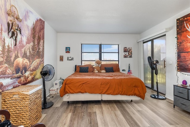 bedroom with light wood-type flooring and multiple windows