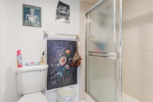 bathroom with toilet and an enclosed shower