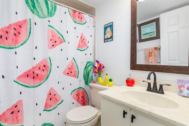 bathroom featuring a textured ceiling, vanity, and toilet