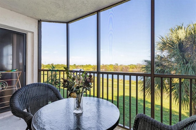 sunroom featuring a water view and a wealth of natural light