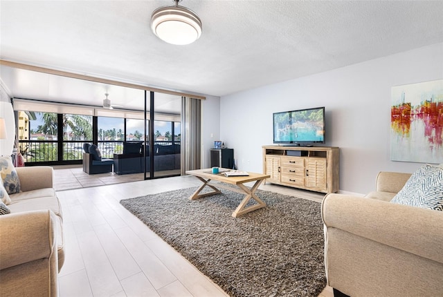 living room featuring floor to ceiling windows, a textured ceiling, and hardwood / wood-style flooring