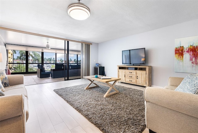 living room featuring a textured ceiling, floor to ceiling windows, and hardwood / wood-style floors