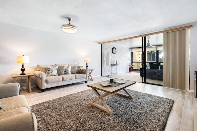 living room with a textured ceiling and light hardwood / wood-style flooring