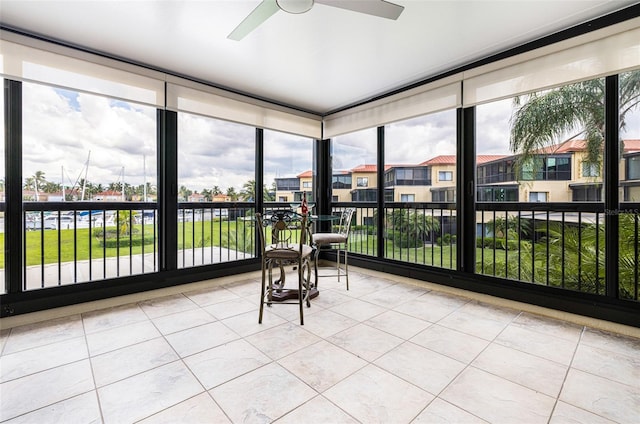 unfurnished sunroom with ceiling fan and plenty of natural light