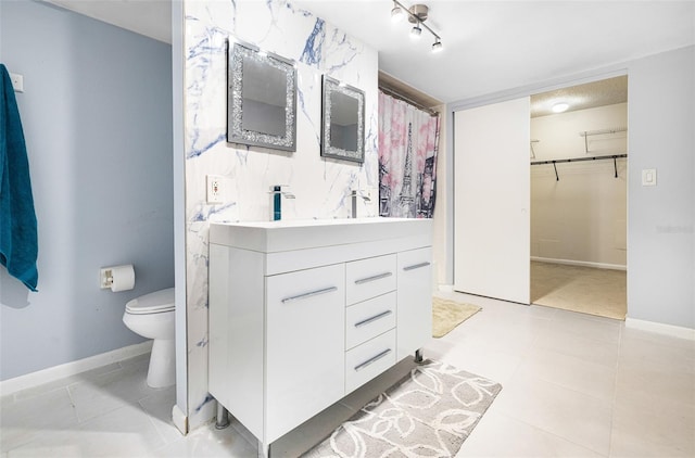 bathroom featuring tile patterned flooring, vanity, and toilet