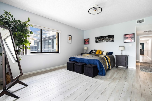 bedroom featuring a textured ceiling and light wood-type flooring