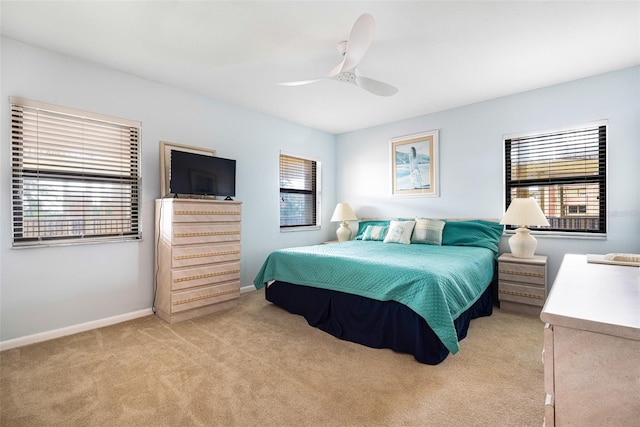 carpeted bedroom with ceiling fan and multiple windows