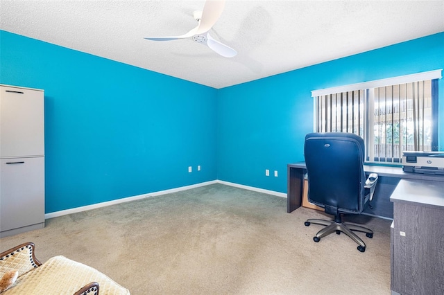 carpeted home office with ceiling fan and a textured ceiling