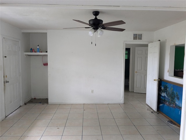 empty room featuring light tile patterned floors and ceiling fan