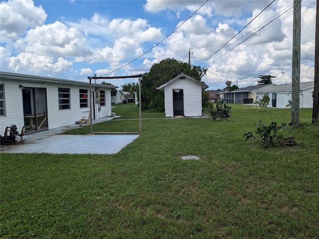 view of yard with a storage shed and a patio