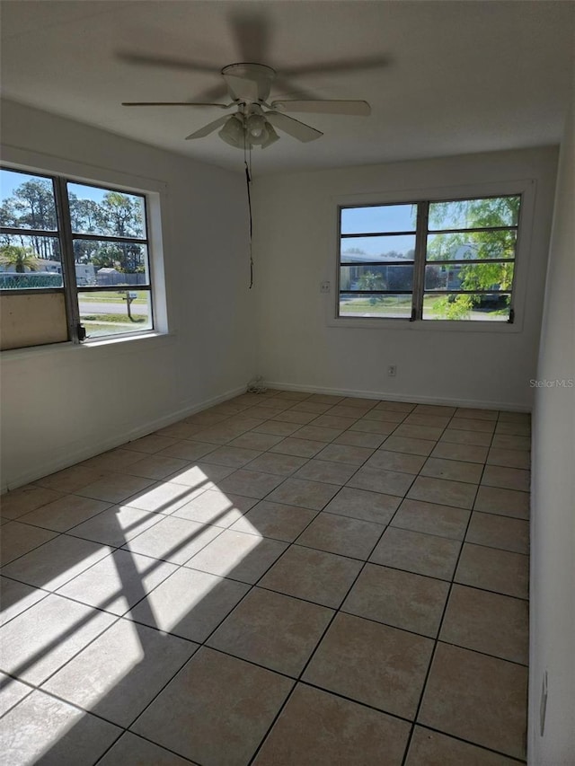 tiled empty room featuring a wealth of natural light and ceiling fan