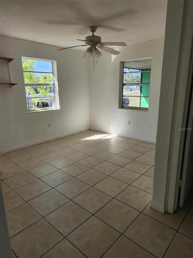 tiled spare room with ceiling fan