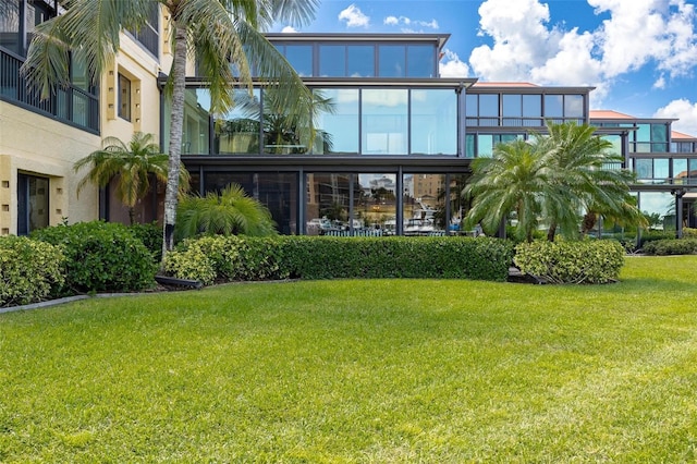 rear view of property featuring a lawn