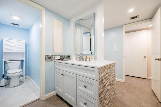 bathroom with decorative backsplash, vanity, and toilet