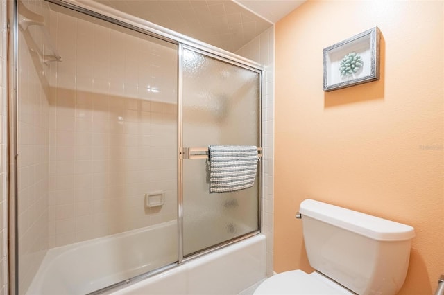 bathroom with enclosed tub / shower combo and toilet