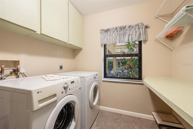 laundry area with separate washer and dryer, light tile patterned floors, and cabinets