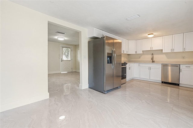 kitchen featuring a textured ceiling, white cabinetry, sink, and appliances with stainless steel finishes