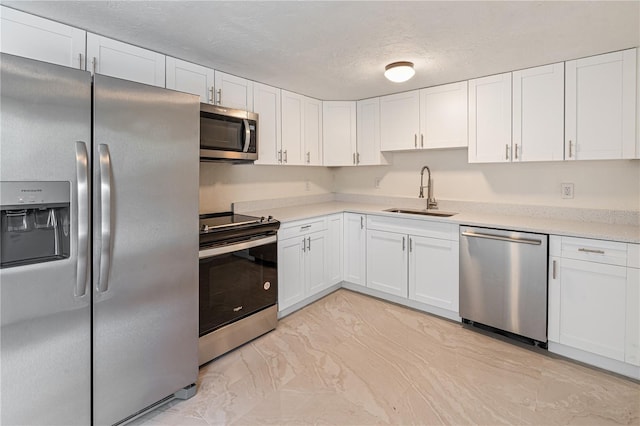 kitchen with white cabinets, sink, appliances with stainless steel finishes, and a textured ceiling