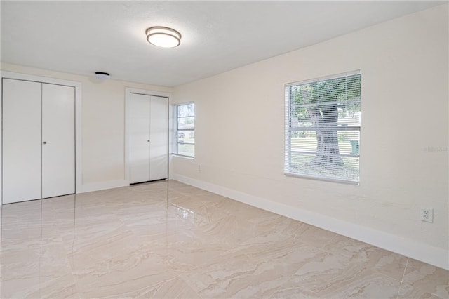 unfurnished bedroom featuring two closets