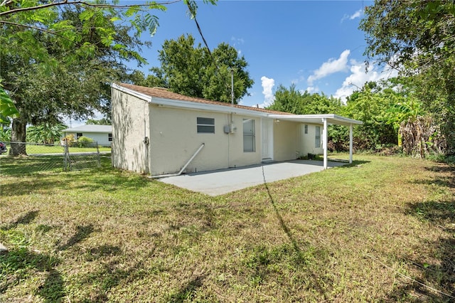 back of house with a yard and a patio