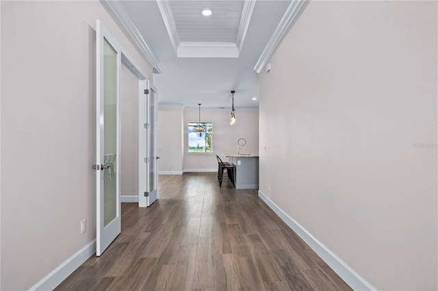 hall featuring ornamental molding, a notable chandelier, and dark hardwood / wood-style flooring