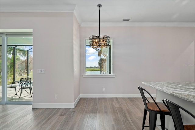 dining room with a notable chandelier, light hardwood / wood-style flooring, crown molding, and a wealth of natural light