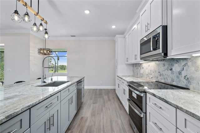 kitchen with sink, white cabinets, stainless steel appliances, and light hardwood / wood-style floors