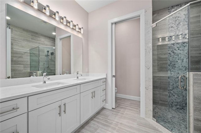 bathroom with vanity, toilet, a shower with shower door, and hardwood / wood-style floors