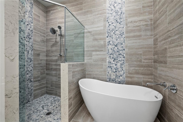 bathroom with tile walls and shower with separate bathtub