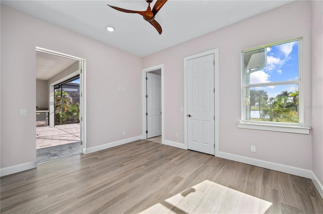 unfurnished bedroom featuring light hardwood / wood-style floors, multiple windows, and ceiling fan