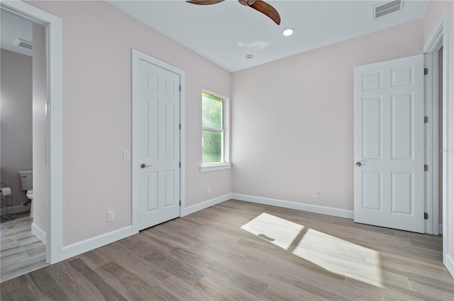 unfurnished bedroom with light hardwood / wood-style flooring, connected bathroom, and ceiling fan