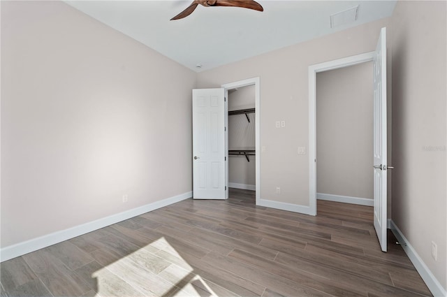 unfurnished bedroom featuring hardwood / wood-style flooring, a closet, and ceiling fan