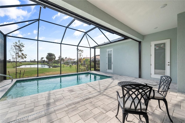 view of swimming pool featuring a patio area, a lawn, a water view, and glass enclosure