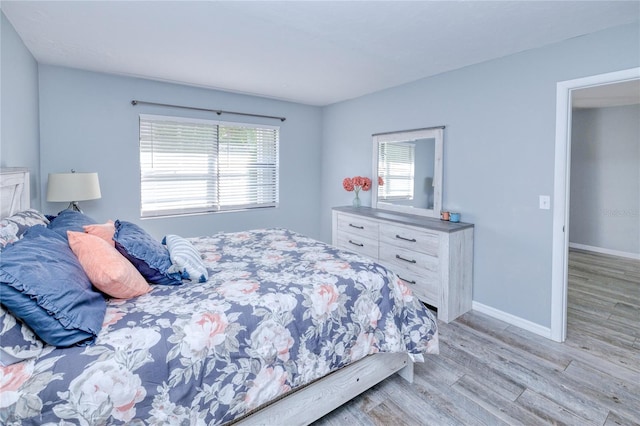 bedroom featuring light wood-type flooring and multiple windows