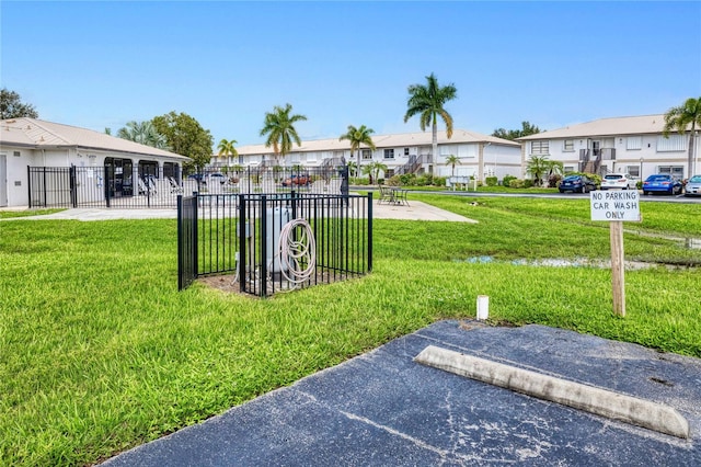 view of property's community featuring a residential view, fence, and a yard