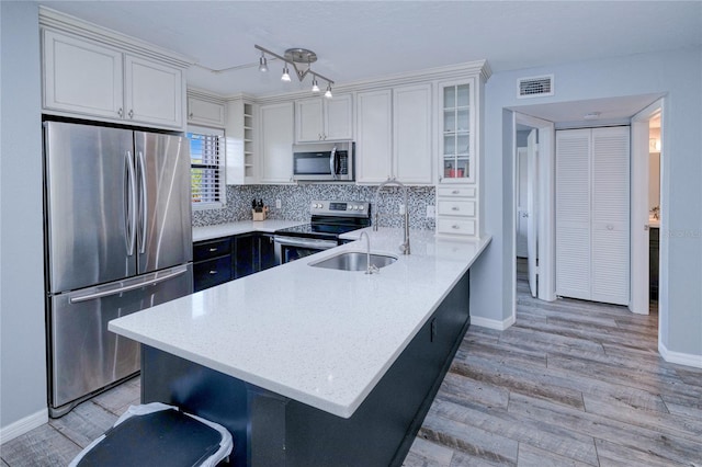 kitchen with stainless steel appliances, white cabinets, glass insert cabinets, and a kitchen breakfast bar