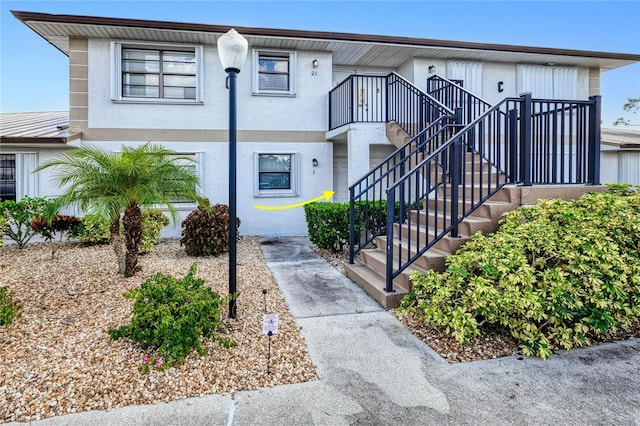 view of property featuring stairway and stucco siding