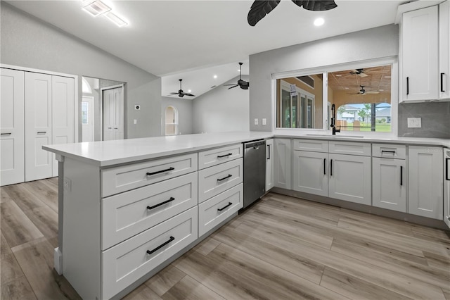 kitchen featuring sink, backsplash, kitchen peninsula, lofted ceiling, and white cabinets