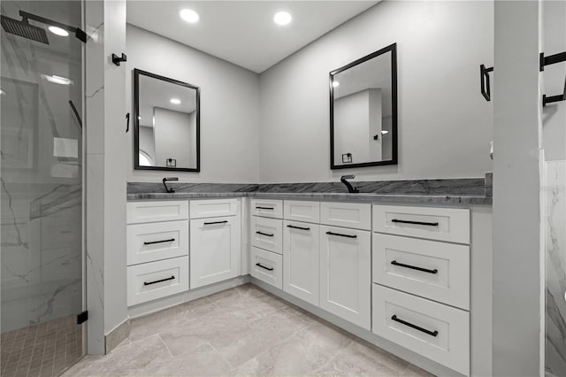 bathroom featuring a shower with door and vanity